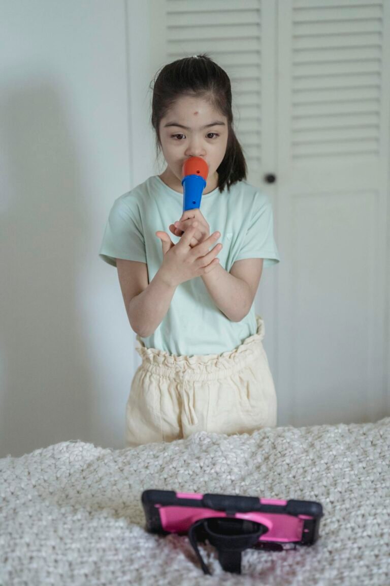 Child singing with a toy microphone indoors, engaging with a digital tablet.
